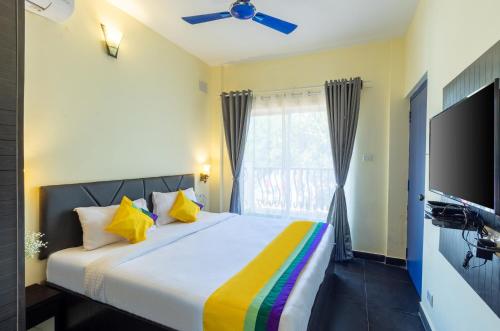 a bedroom with a large bed and a tv at Blue Door in Morjim