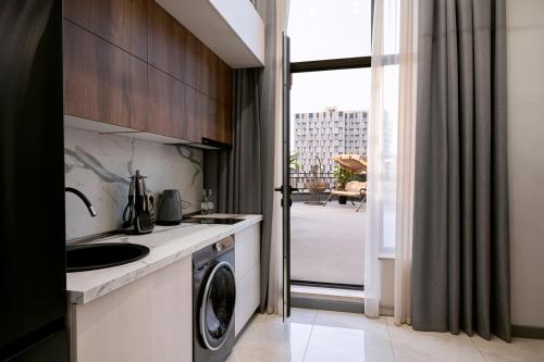 a kitchen with a sink and a washing machine at Hilltop North Avenue by Stellar Hotels, Yerevan in Yerevan