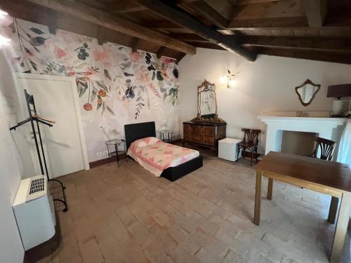 a bedroom with a bed and a table and a fireplace at Agriturismo e Az. Agricola Ma.Mi in Sale