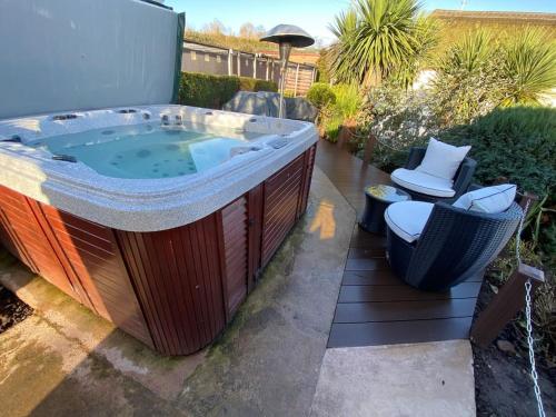 a large jacuzzi tub sitting on a patio at The Studio with Hot Tub in East Budleigh in beautiful countryside in East Budleigh