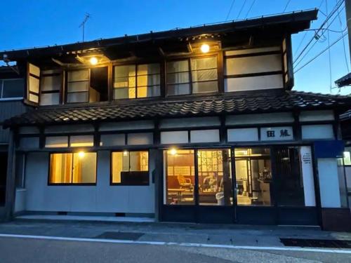 un edificio con luces encendidas delante de él en 囲炉裏町家Guesthouse FUJITA 一棟貸切 villa 無料駐車場 en Hakusan