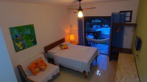 Zimmer mit einem Bett, einem Tisch und einem Stuhl in der Unterkunft Imbassai Flat in Imbassai