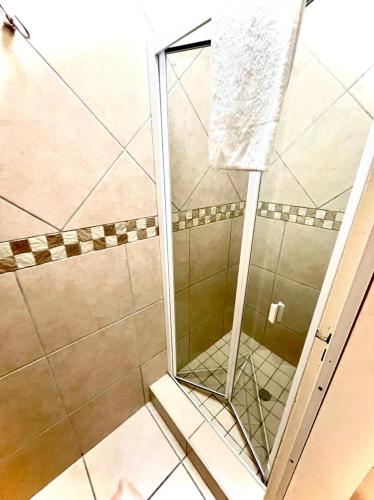 a shower with a glass door in a bathroom at Perna Perna Lodge St Lucia in St Lucia