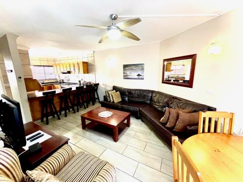 a living room with a couch and a table at Perna Perna Lodge St Lucia in St Lucia