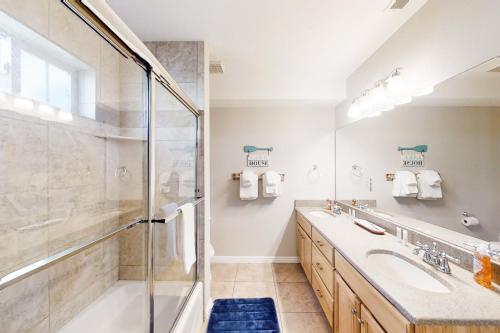 a bathroom with a shower and a sink and a tub at Kokomo Kottage in Garden City