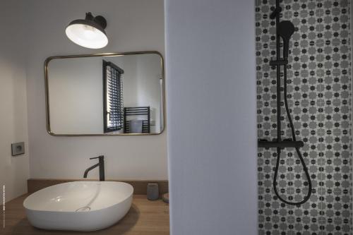 une salle de bain avec un lavabo blanc et un miroir dans l'établissement La villa Terracotta - Villa de rêve au calme à 900 m de l'océan avec piscine chauffée, à Sainte-Marie de Ré