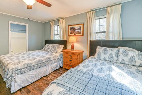 a bedroom with two beds and a nightstand and two windows at SML Ski School in Moneta