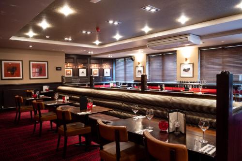 um restaurante com mesas e cadeiras e um bar em Miller & Carter Heaton Chapel by Innkeeper's Collection em Manchester