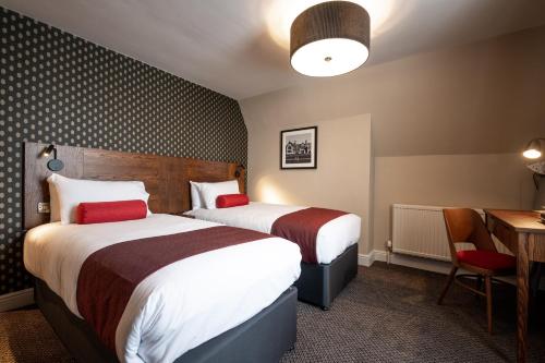 a hotel room with two beds and a table at Miller & Carter Heaton Chapel by Innkeeper's Collection in Manchester