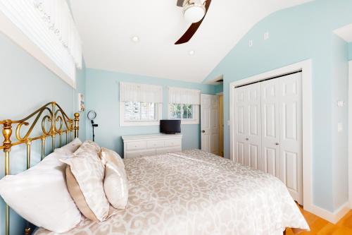 een slaapkamer met een bed met blauwe muren en een plafond bij Eastwind Elegance in Ogunquit