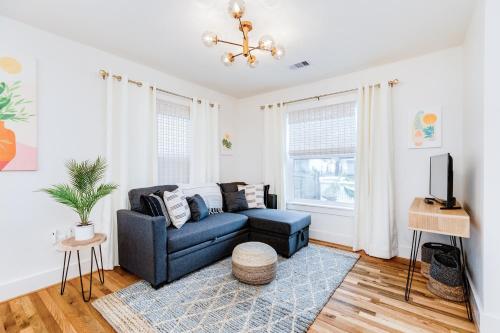 a living room with a blue couch and a tv at Barefoot Coastal Cottage in Galveston