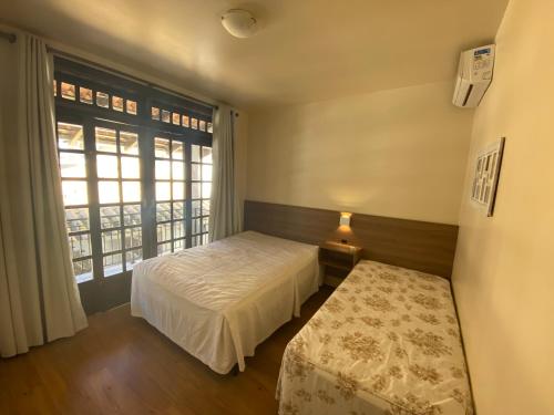Un dormitorio pequeño con una cama y una ventana. en Férias a beira mar - Brilhos do sol, en Bombinhas