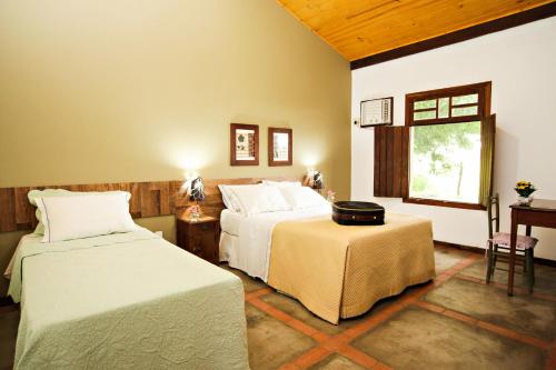 A bed or beds in a room at Pousada Pequi