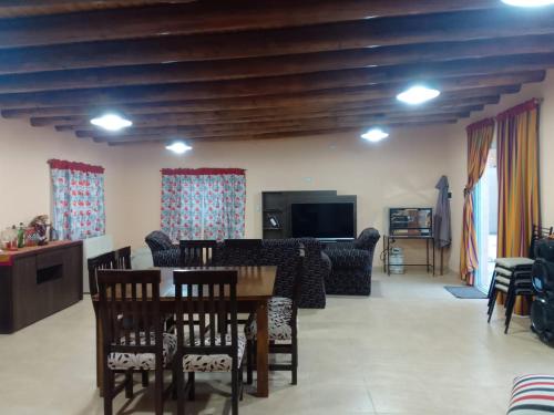 sala de estar con mesa, sillas y TV en Casa Kloeh en Luján de Cuyo