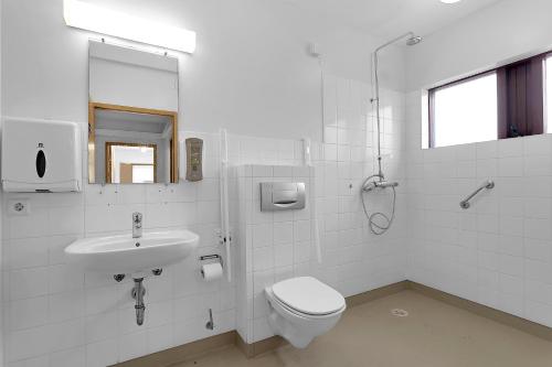 a white bathroom with a toilet and a sink at Víðines Guesthouse in Reykjavík