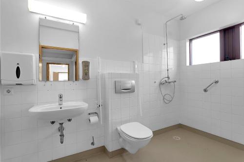 Baño blanco con aseo y lavamanos en Víðines Guesthouse, en Reikiavik