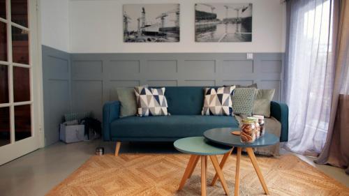 a living room with a blue couch and a table at Houseboat apartment with water terrace, free bikes & fast wifi in Amsterdam