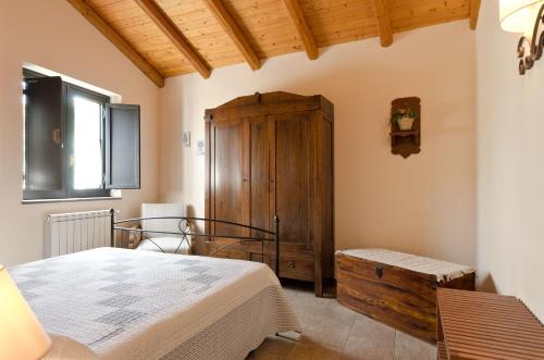 um quarto com uma cama e um armário de madeira em Case Vacanze Dietroserra em Viagrande