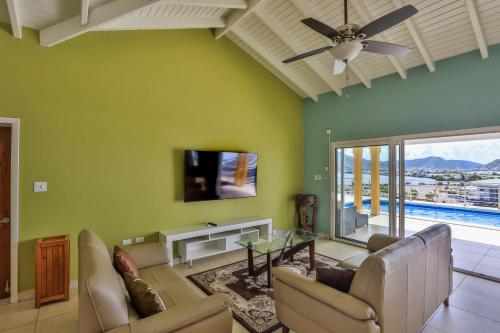 a living room with a couch and a tv at Reflection Z 5 Star Villa in Maho Reef