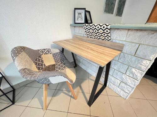 une table et une chaise assises à côté d'un comptoir dans l'établissement Vue sur Jardin Parking Ascenseur Un-Séjour-à-Part, à Metz