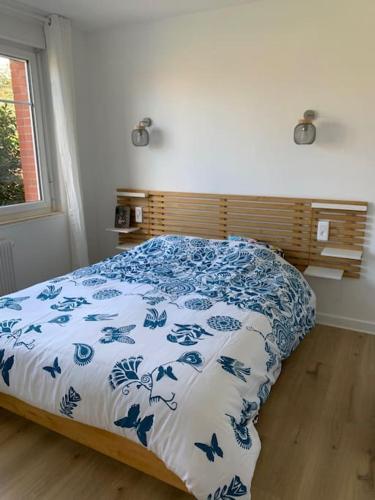 une chambre avec un lit avec une couverture bleue et blanche dans l'établissement Au 154 Bis - Joli Appartement avec Grande Terrasse et proche de la plage à Malo, à Dunkerque