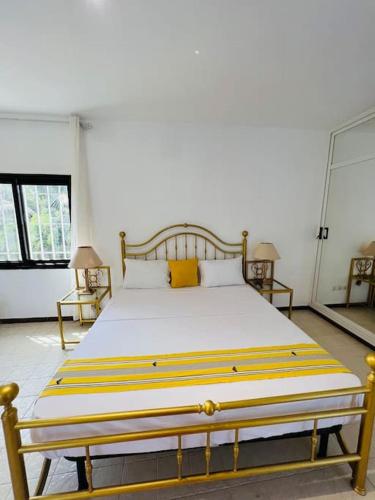 a large bed in a room with two lamps at TérangaLux Collection Villa Green House Mamelles in Dakar