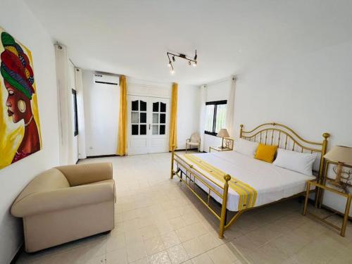 a bedroom with a bed and a chair in it at TérangaLux Collection Villa Green House Mamelles in Dakar