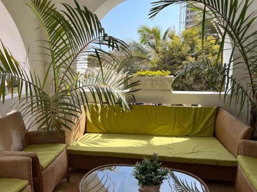 a green couch sitting on a balcony with plants at TérangaLux Collection Villa Green House Mamelles in Dakar