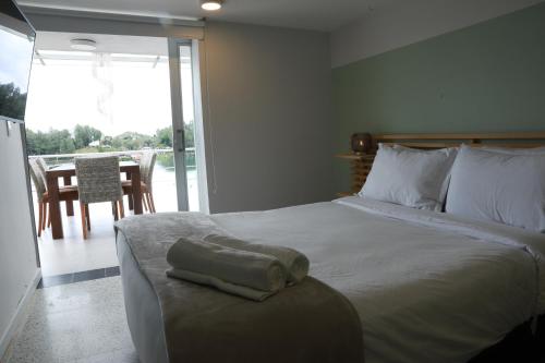 a bedroom with a bed and a balcony with a table at Hotel Bania travels in Guatapé