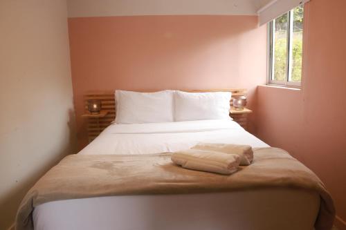 a bedroom with a bed with two towels on it at Hotel Bania travels in Guatapé
