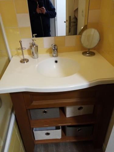 un homme prenant une photo d'un lavabo dans la salle de bains dans l'établissement 2 pièces avec terrasse et vue sur les pistes, à Isola 2000