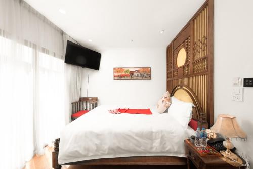 a bedroom with a bed with a doll laying on it at Veshia Hotel & Spa in Hanoi