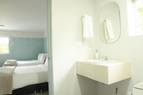 a bathroom with a sink and a bed with a mirror at Hotel Bania travels in Guatapé
