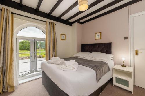 a bedroom with two beds and a window at Bower House Inn in Eskdale