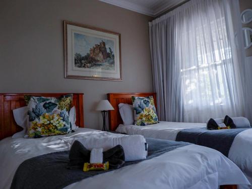 um quarto de hotel com duas camas e uma janela em Authentic Mossel Bay em Mossel Bay