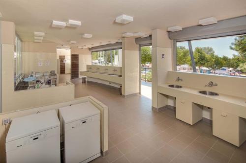 a large bathroom with two sinks and a large window at Easyatent Safari tent Park Umag in Umag