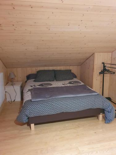 Gite de la Daniere في Dangy: غرفة نوم بسرير في غرفة خشبية