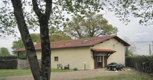 un piccolo edificio bianco con tetto rosso di Les Chênes 2 - cadre verdoyant a Eugénie-les-Bains