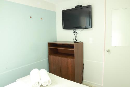a room with a tv and a bed with towels at Hotel Bania travels in Guatapé