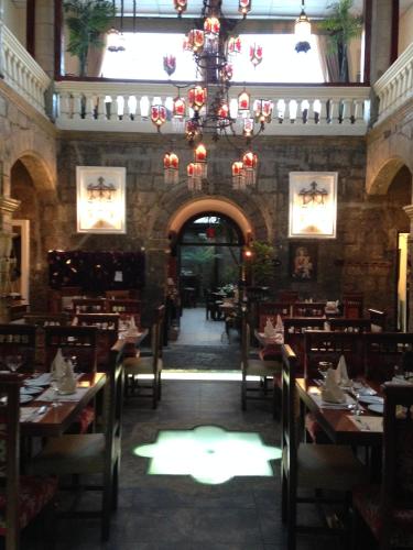 a dining room with tables and chairs and a chandelier at Roka Plaza Hotel Boutique in Ambato