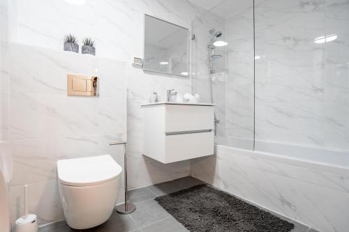 a white bathroom with a toilet and a shower at Central and Luxury New 2BR&2Bth - Private Parking in Jerusalem