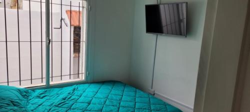 Habitación pequeña con cama y ventana en Depto en Tandil Garibaldi 388 en Tandil