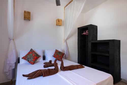 een slaapkamer met 2 bedden en bruine dekens bij Nyumbani Residence Apartments in Jambiani