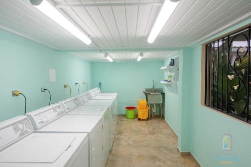 a bathroom with white sinks and a blue wall at Dover Court Apartments - Steps to St Lawrence Gap in Christ Church