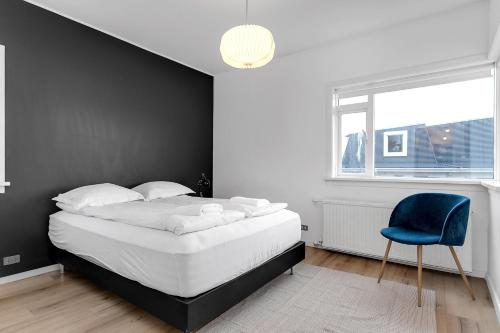 a bedroom with a bed and a blue chair at Relaxing Reykjavik Apartment in Reykjavík
