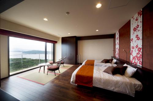 a bedroom with a large bed and a large window at Kyukamura Kishu-Kada in Wakayama