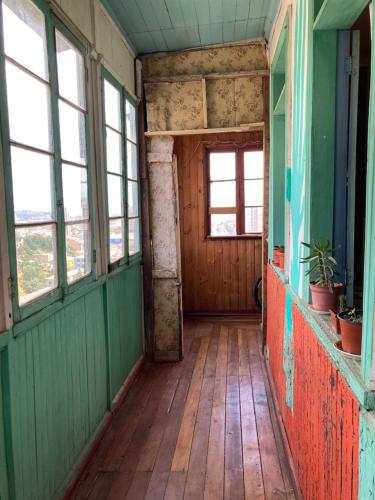 an empty hallway of an old house with windows at Hostal brons in Valparaíso