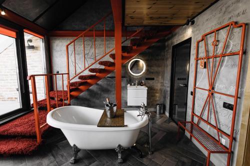 a bathroom with a white tub and a staircase at Masoch. Hotel & Cafe in Lviv