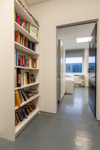 a hallway with book shelves filled with books at BAZZE in Klaipėda
