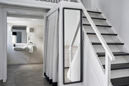 a bathroom with a staircase with a mirror at Mr and Mrs White Oia - Santorini in Oia